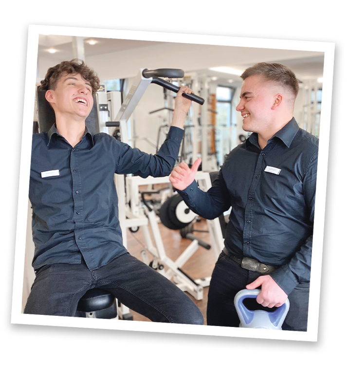 Polaroidfoto von zwei Auszubildenden die im Fitnessstudio Fitnessgeräte ausprobieren
