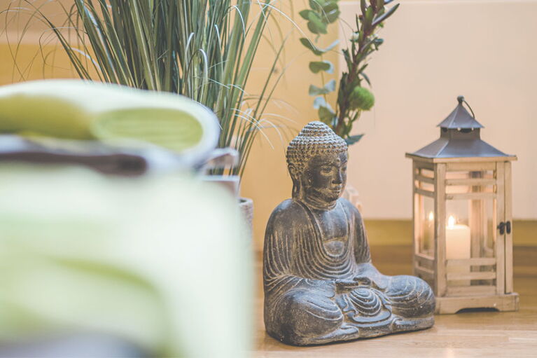 Detailaufnahme Buddhafigur und Kerze in der Saunalandschaft des Sporthotel Grafenwald